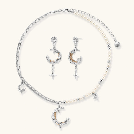 Mixed-metal jewelry set featuring layered necklaces with crescent moon pendant and pearl beads, plus matching star-drop earrings.