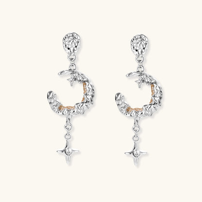 Detailed eco-brass dangle earrings featuring crescent moons with gold rope details and dangling star charms on white background.