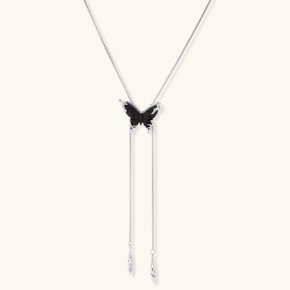 Wooden butterfly pendant necklace with cascading silver-toned chains on adjustable chain, available in amber and black.