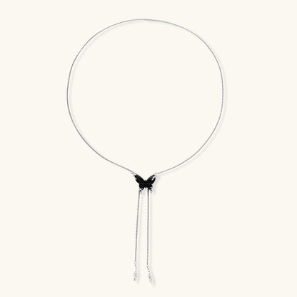 Wooden butterfly pendant necklace with cascading silver-toned chains on adjustable chain, available in amber and black.
