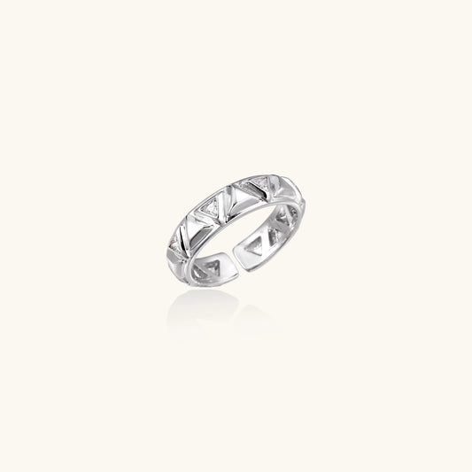 White gold adjustable ring with geometric triangle cutouts and zirconia stones on cream background