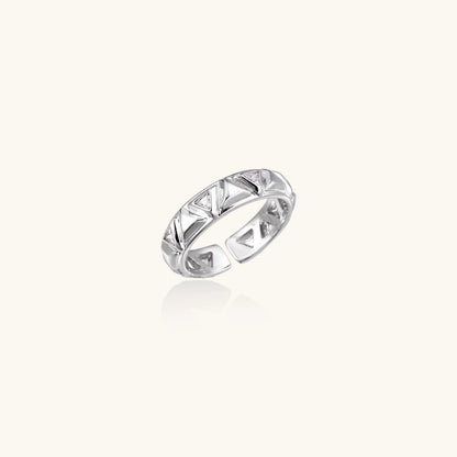 White gold adjustable ring with geometric triangle cutouts and zirconia stones on cream background