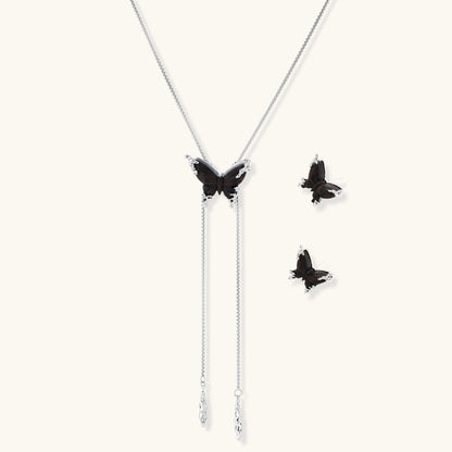 Dark wood butterfly earrings and necklace with silver chain accents on white background, showing natural grain texture.
