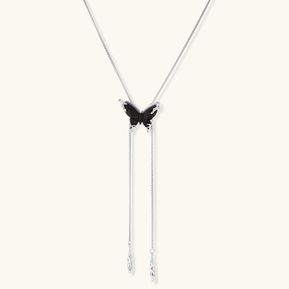 Dark wood butterfly earrings and necklace with silver chain accents on white background, showing natural grain texture.