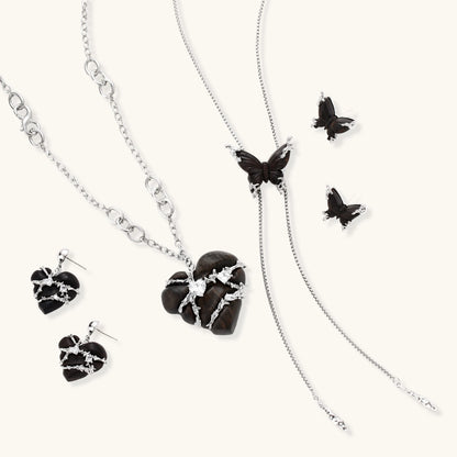 Dark wood butterfly earrings and necklace with silver chain accents on white background, showing natural grain texture.