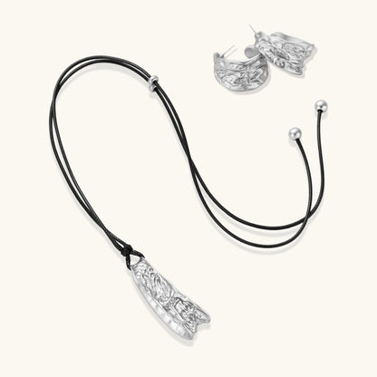 Textured silver jewelry set with floral engravings featuring adjustable cord necklace and matching hoop earrings
