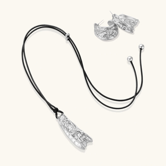 Textured silver jewelry set with floral engravings featuring adjustable cord necklace and matching hoop earrings