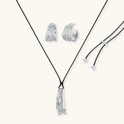 Textured silver jewelry set with floral engravings featuring adjustable cord necklace and matching hoop earrings