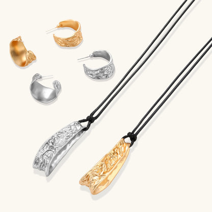 Textured silver jewelry set with floral engravings featuring adjustable cord necklace and matching hoop earrings