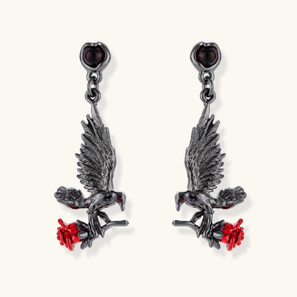 Dark gunmetal jewelry set featuring detailed raven pendants carrying red enamel roses with layered pearl and chain necklaces