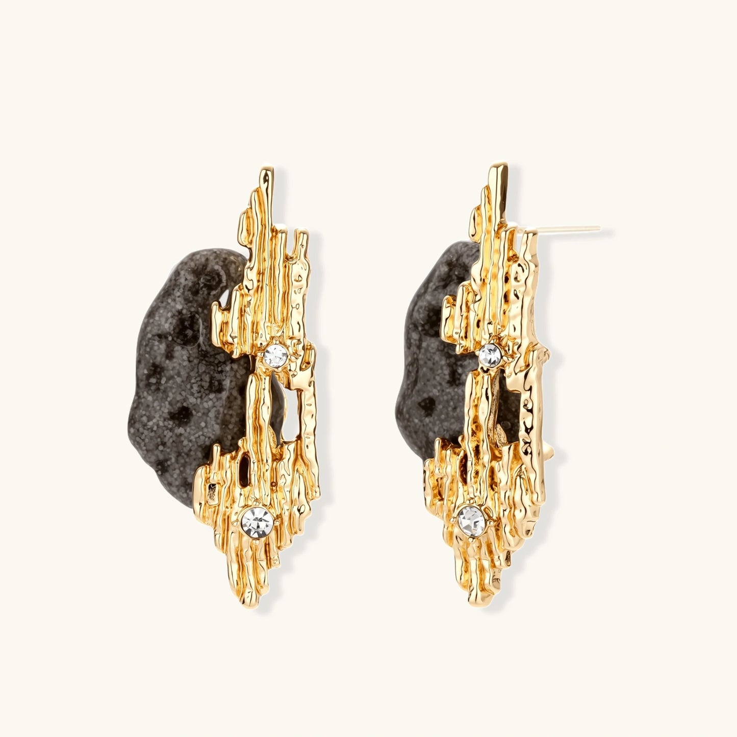 Sculptural statement earrings with textured volcanic stones and flowing silver metal design with crystal accents