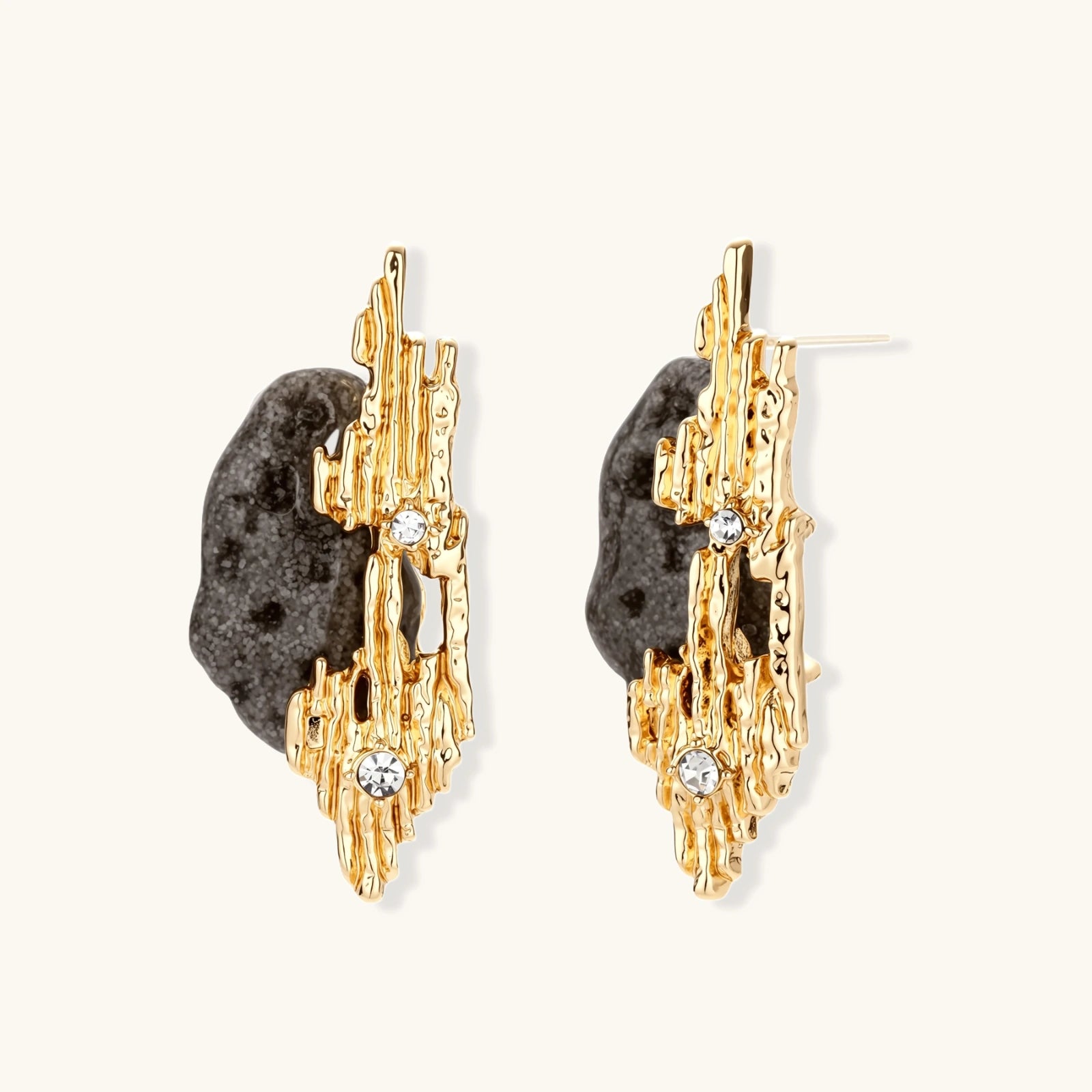 Sculptural statement earrings with textured volcanic stones and flowing silver metal design with crystal accents