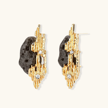 Sculptural statement earrings with textured volcanic stones and flowing silver metal design with crystal accents