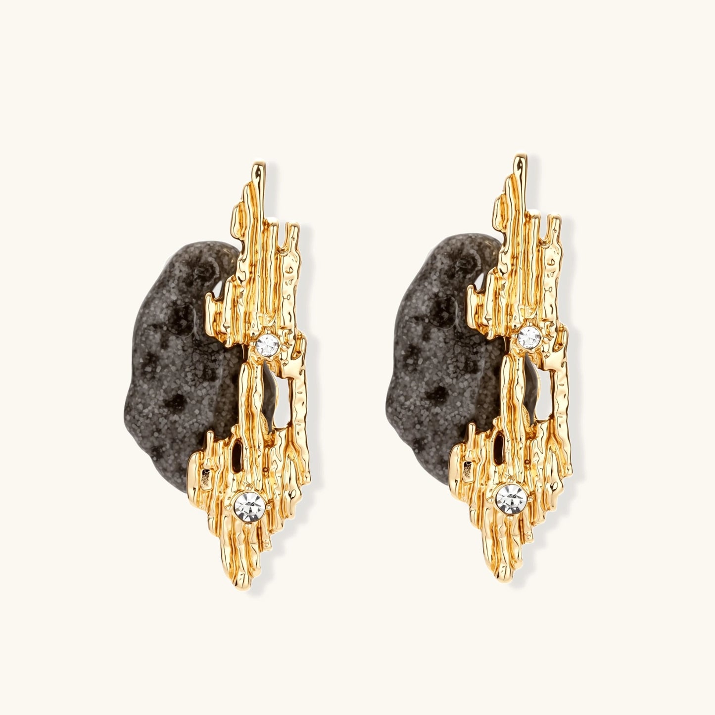 Sculptural statement earrings with textured volcanic stones and flowing silver metal design with crystal accents