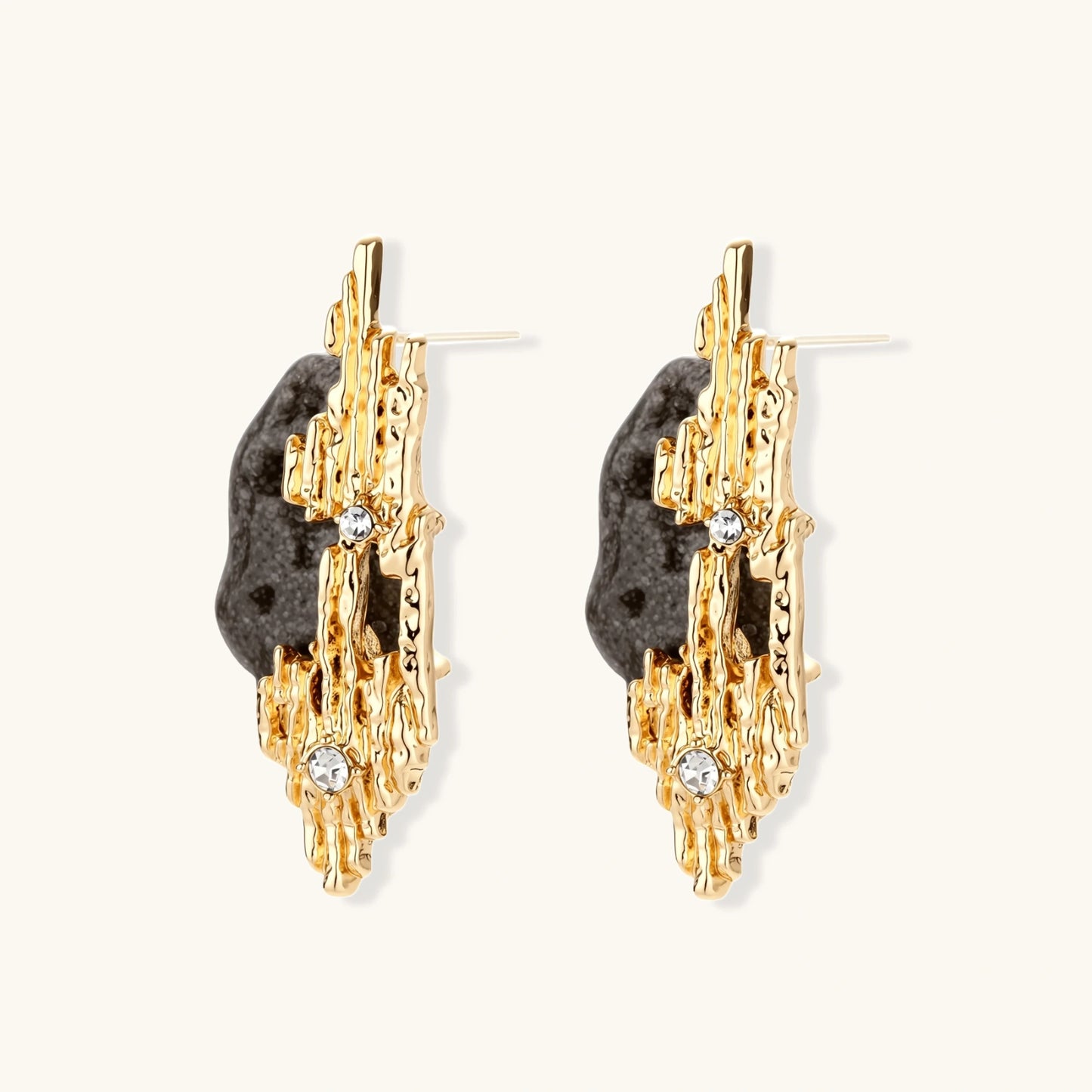 Sculptural statement earrings with textured volcanic stones and flowing silver metal design with crystal accents