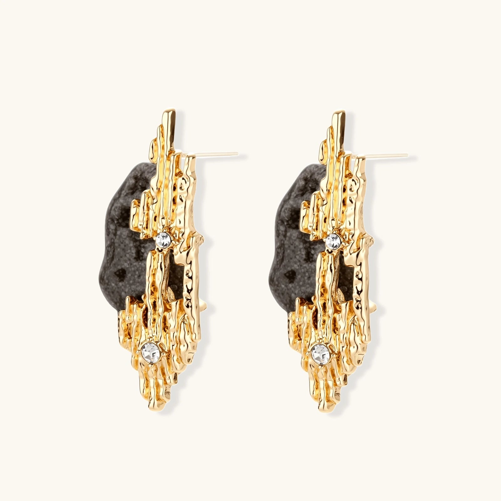 Sculptural statement earrings with textured volcanic stones and flowing silver metal design with crystal accents