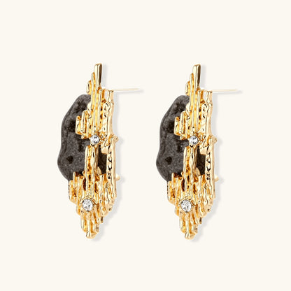 Sculptural statement earrings with textured volcanic stones and flowing silver metal design with crystal accents